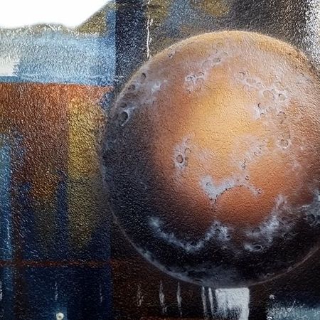 Wandbemalung einer braun-bronzenen Kugel vor einem dunklen Hintergrund.