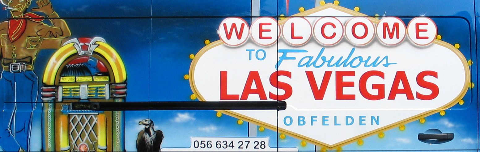 Lackierung auf einem Transporter mit 'Welcome to Las Vegas' Schild und einem Cowboy neben einem Spielautomaten.